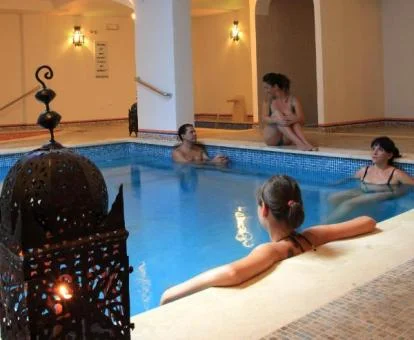 Varias personas disfrutan del espacio de bienestar de este acogedor hotel boutique.