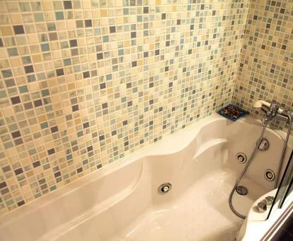 Bañera de hidromasaje privada en el baño de este coqueto apartamento tradicional.