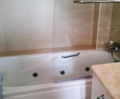Baño con bañera de hidromasaje privada de este moderno apartamento.