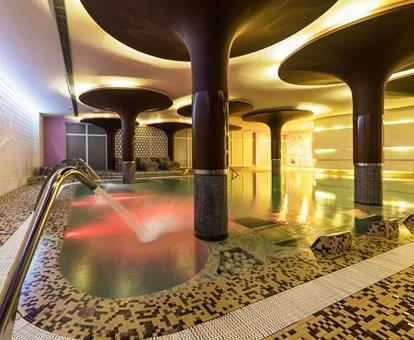 Piscina cubierta con elementos de hidroterapia del spa del hotel.