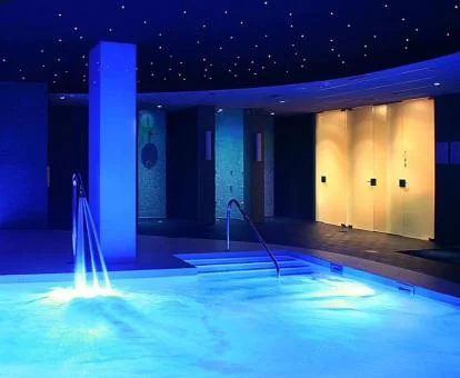 Piscina cubierta con elementos de hidroterapia del spa del hotel.
