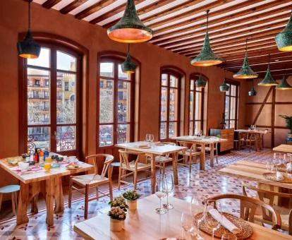 Precioso comedor con amplias ventanas y vistas a la ciudad de este hotel romántico.