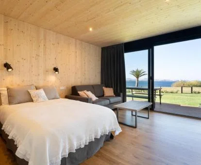 Dormitorio con vistas al mar y acceso directo al jardín de una de las cabañas del establecimiento.