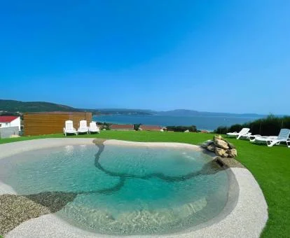 Piscina exterior con vistas al mar de este establecimiento de casas independientes.