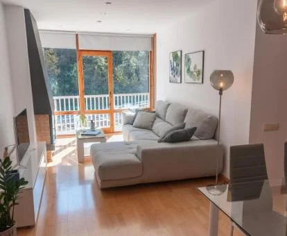 Interior de este acogedor apartamento con amplios ventanales y vistas a la naturaleza.