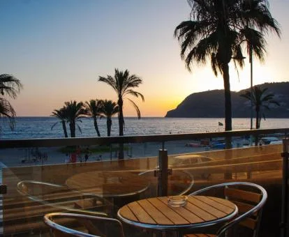 Terraza con comedor y fabulosas vistas al mar con un bello atardecer de fondo de este hotel con encanto.