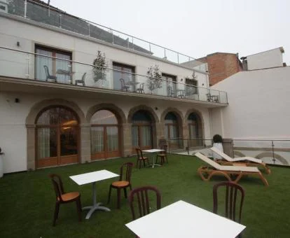 Hotel boutique con amplia zona exterior amueblada y habitaciones con balcón.