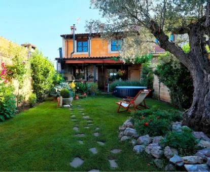 Coqueta zona exterior con jardín de esta casa independiente.