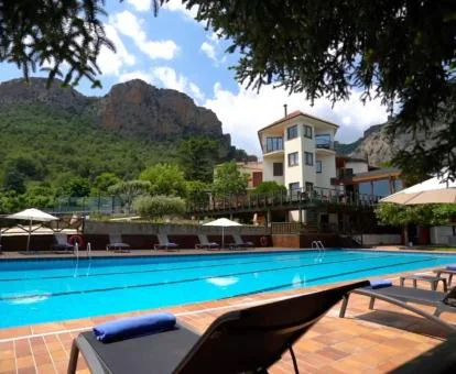 Hotel con encanto rodeado de naturaleza con una gran piscina exterior.