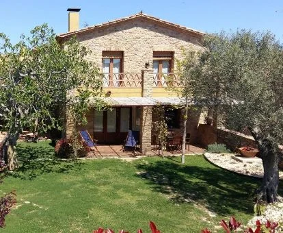 Hermoso alojamiento rural con amplios jardines y zonas de estar en el exterior.