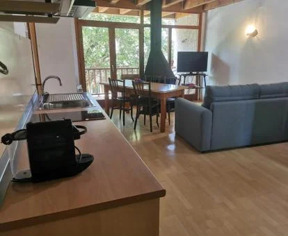 Interior de uno de los acogedores apartamentos con balcón y vistas a los jardines del alojamiento.
