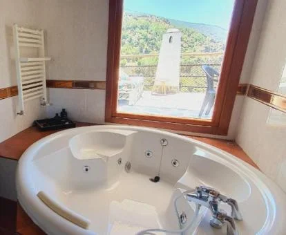Amplio jacuzzi privado con vistas a las montañas de este apartamento independiente.
