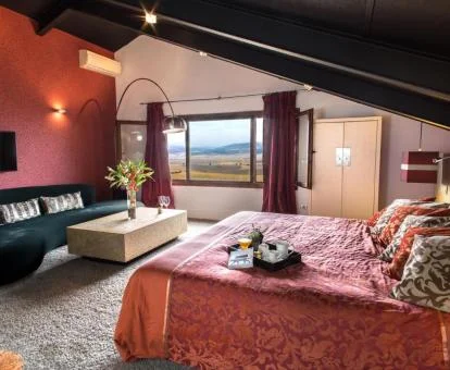 Una de las habitaciones con zona de estar y vistas al campo de este hotel rural.