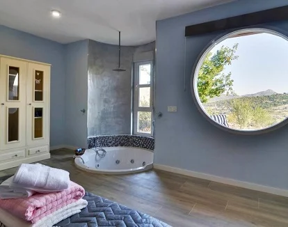 Casa rural con jacuzzi privado en Robledo de Chavela a menos de 69 kilometros de Madrid ideal para un fin de semana romántico Foto del jacuzzi a ras de suelo cerca de la cama y con vistas al campo en la casa rural de un dormitorio en Robledo de Chavela