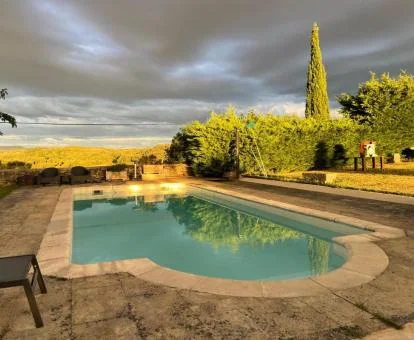 Zona exterior con piscina rodeada de vegetación de esta coqueta casa rural independiente.