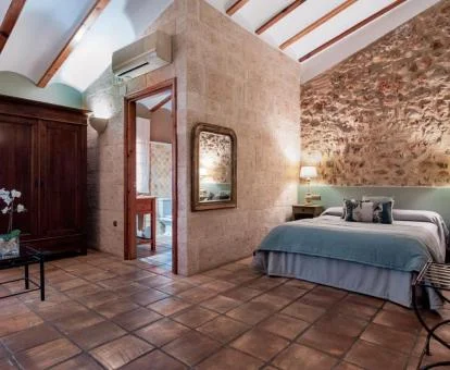 Una de las coquetas habitaciones con paredes de piedra a la vista.