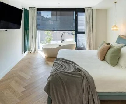 Una de las hermosas habitaciones con bañera junto a la cama del hotel.