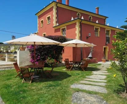 Hotel con encanto con amplios jardines y mobiliario exterior.