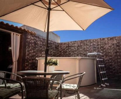 Agradable terraza con piscina y mobiliario de este alojamiento rural.