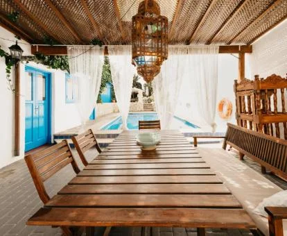 Zona exterior de esta preciosa casa con comedor bajo porche y piscina al aire libre.