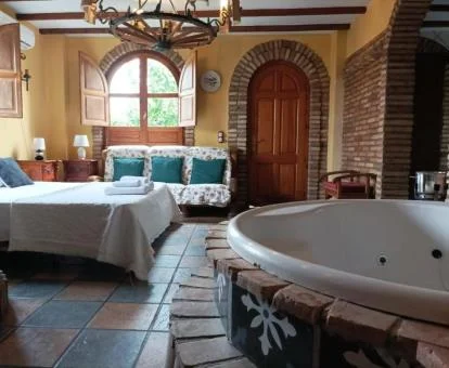 Dormitorio con bañera de hidromasaje privada junto a la cama del apartamento superior de este establecimiento.