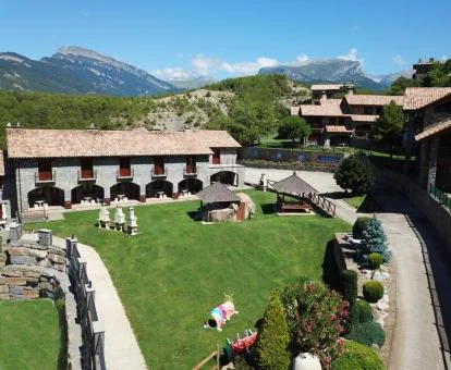 Edificio de este establecimiento rural con amplios jardines y mobiliario al aire libre.