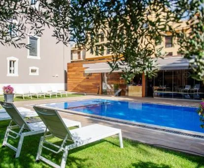 Agradable zona exterior con piscina y jardín de este hotel boutique.