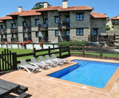 Complejo de apartamentos con piscina y zonas exteriores.