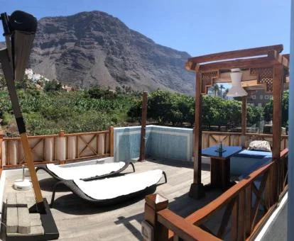 Terraza con mobiliario y vistas a las montañas de uno de los apartamentos del establecimiento.