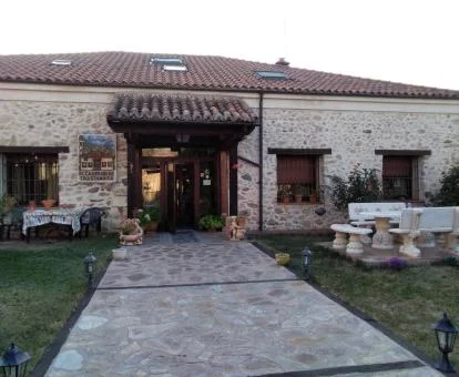 Hotel rural con jardín y mobiliario exterior.