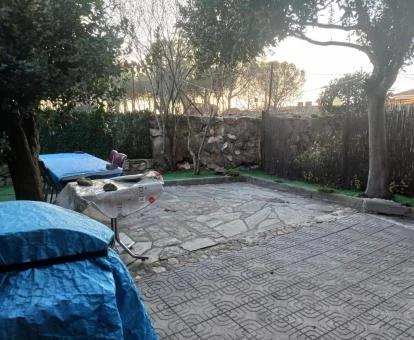 Agradable terraza trasera de esta casa independiente con barbacoa y mobiliario.