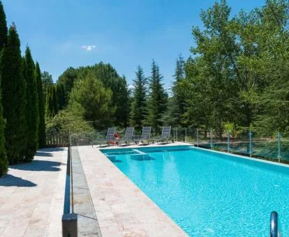 Amplia piscina rodeada de naturaleza de este alojamiento rural.