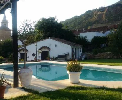 Zona exterior ajardinada con piscina rodeada de vegetación de este establecimiento rural.