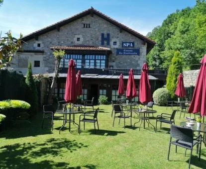 Edificio de este acogedor hotel rural con jardines y mobiliario.