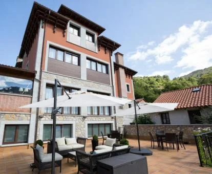 Edificio de este hotel boutique con terraza y mobiliario exterior.