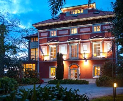 Hermoso edificio con iluminación nocturna y rodeado de jardines de este hotel boutique.