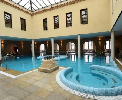 Piscina cubierta con elementos de hidroterapia del spa del hotel.