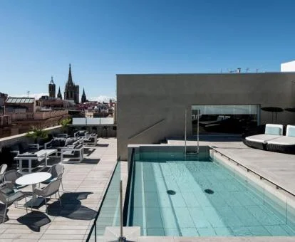 Terraza con piscina y mobiliario con vistas a la ciudad del hotel.