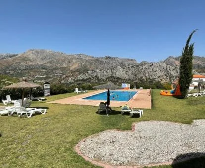 Gran extensión de jardines con piscina y vistas a las montañas de este precioso complejo rural de apartamentos.