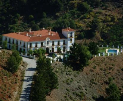 Coqueto hotel boutique con piscina exterior rodeado de vegetación.