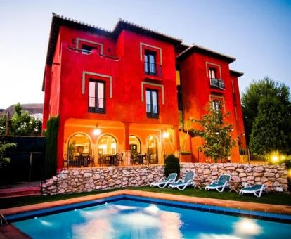 Hotel con encanto con piscina exterior rodeada de vegetación.