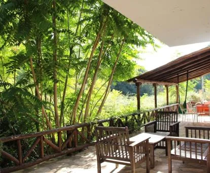 Acogedora terraza privada con mobiliario y vistas a la naturaleza de este apartamento.