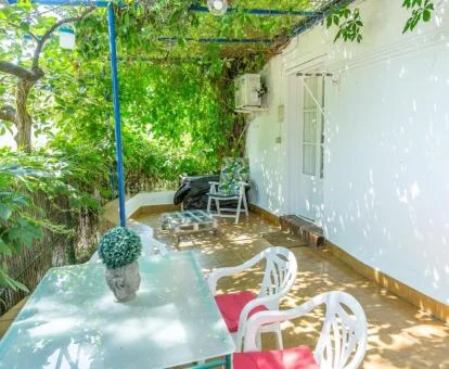 Agradable zona exterior con terraza y mobiliario al aire libre de esta casita acogedora rodeada de vegetación.