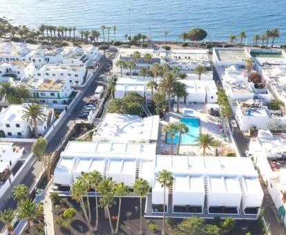 Hotel con piscina exterior y bellos jardines ubicado cerca del mar y visto desde arriba.