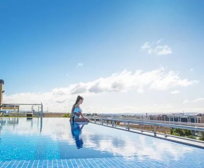 Mujer disfrutando de la preciosa piscina de este hotel con encanto con fabulosas vistas a la ciudad.