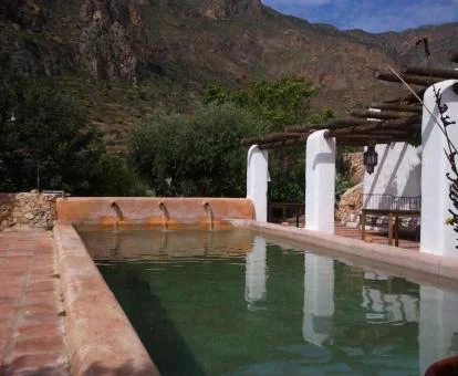 Zona exterior con piscina y vistas al campo que rodea el hotel.