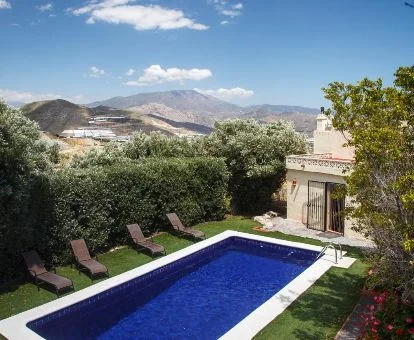 Agradable zona exterior ajardinada con piscina y vegetación de esta casa rural independiente.
