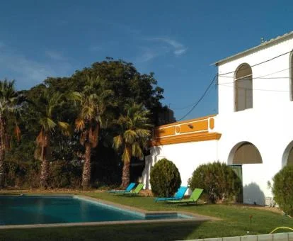 Edificio de este cortijo con amplios jardines y piscina al aire libre.
