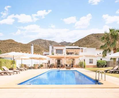 Hermoso cortijo con piscina exterior rodeado de montañas.