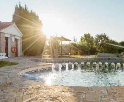 Zona exterior con piscina y vegetación de este establecimiento rural.